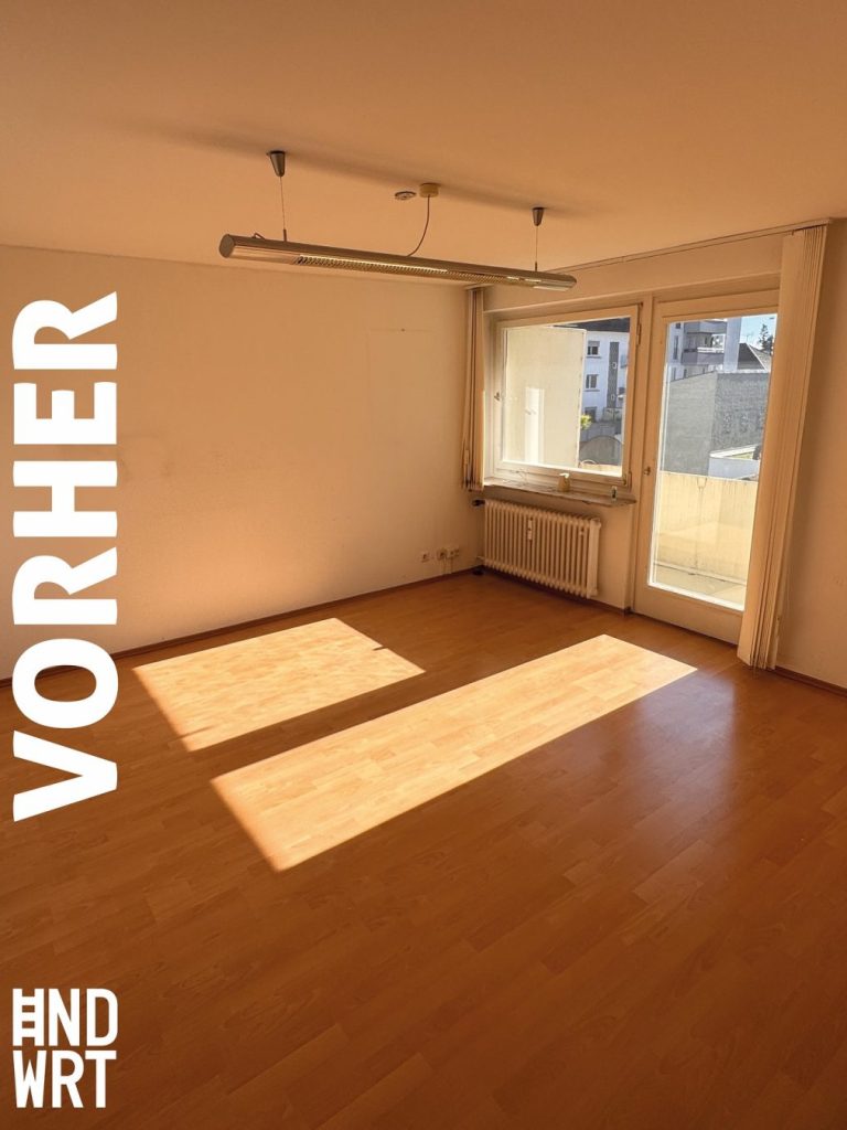 Leerer Raum mit Parkettboden, Heizkörper unter Fenster und Balkontür, vor Abbrucharbeiten