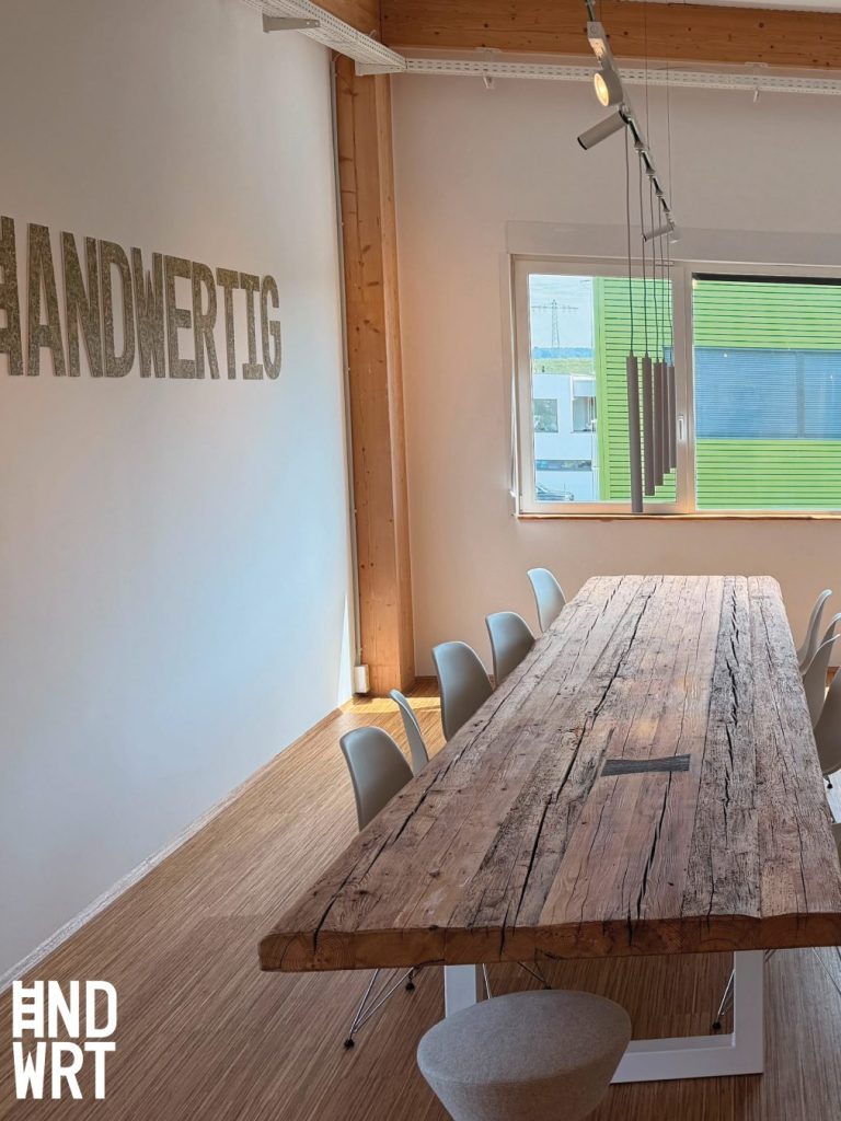 Besprechungsraum mit weißem Kunststofffenster, Holzdecke und rustikalem Holztisch