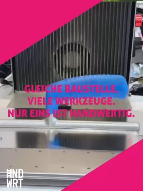 Heizkörper mit vertikalen Lamellen in Anthrazit vor weißer Wand auf einer Baustelle