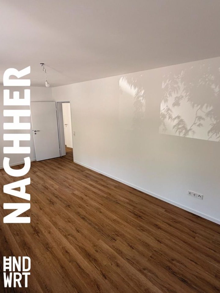 Sanierter Wohnraum mit braunem Laminatboden, weißen Wänden mit Tapetenmuster und weißer Zimmertür