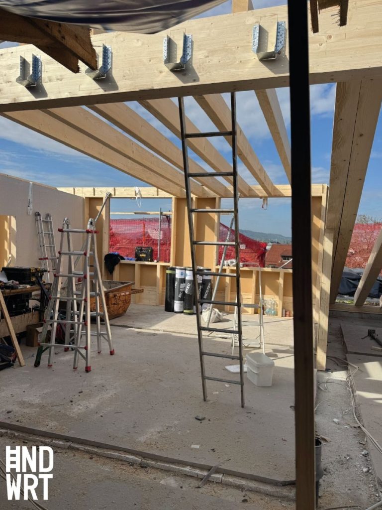 Rohbau mit Holzständerwänden und offener Dachkonstruktion aus Brettschichtholz mit Metallverbindern